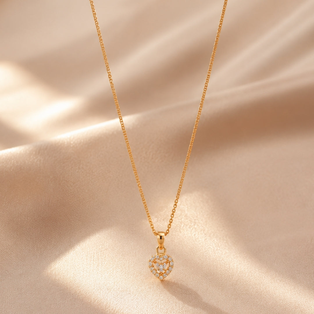 Gold-tone sparkling heart pendant necklace styled on a soft light background
