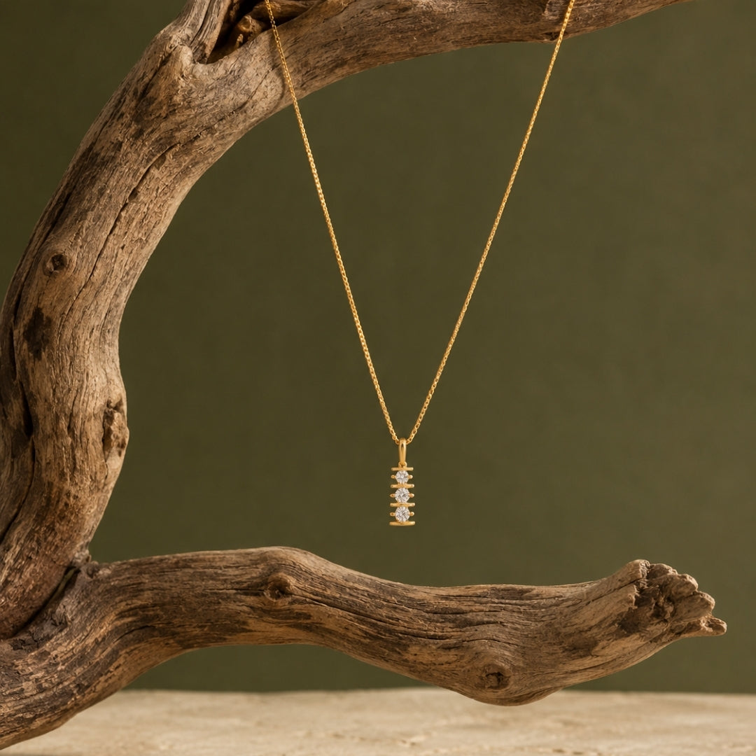 Gold-tone double-star pendant necklace styled on dark satin and natural wood