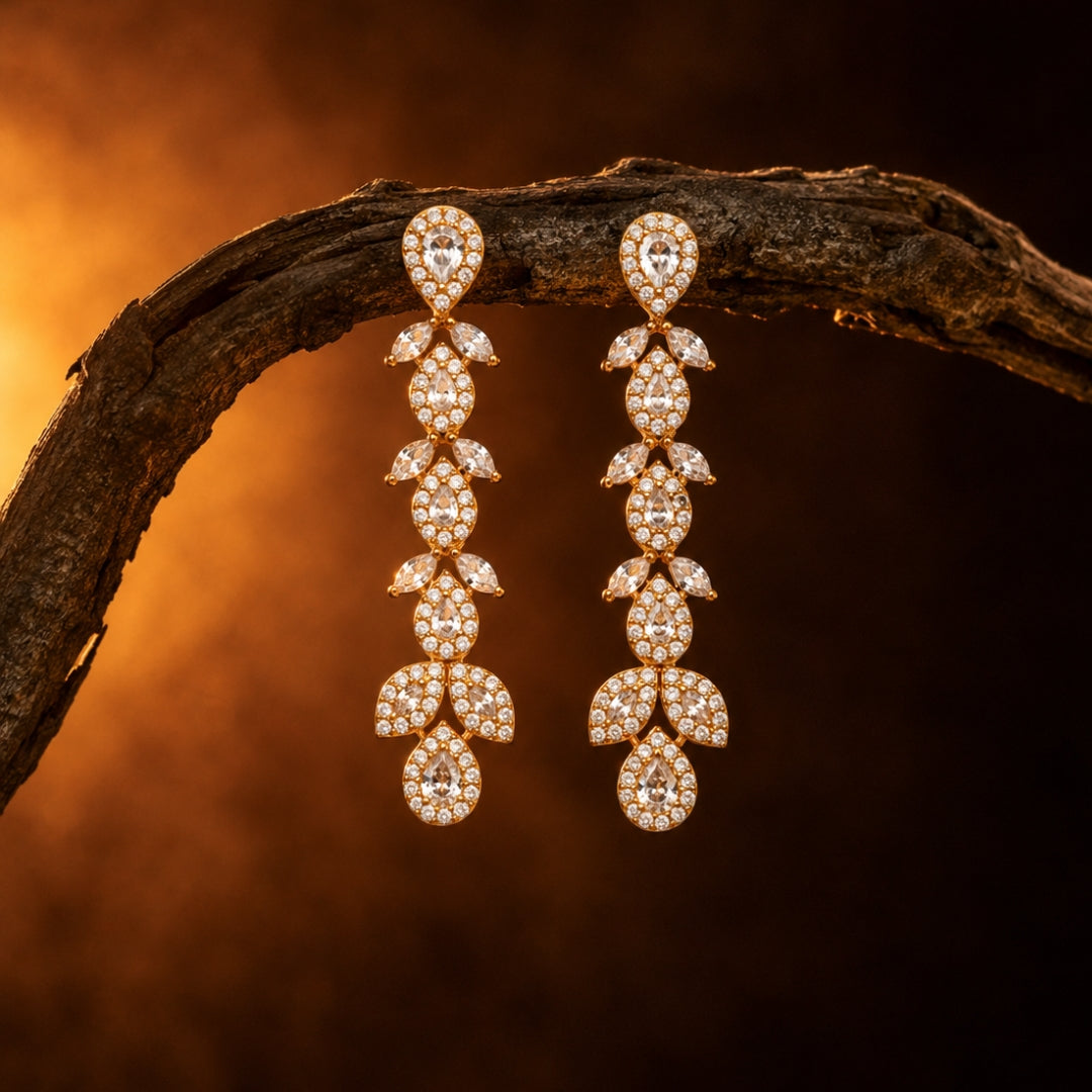 Miayaa Feuille Dorée Cascade Earrings - warm amber lifestyle shot on driftwood