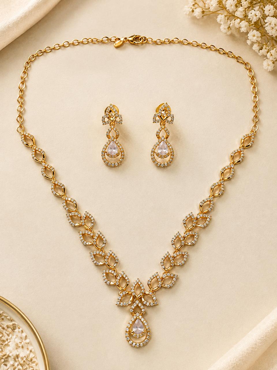 Gold-tone crystal leaf-link necklace with pear-drop pendant and matching drop earrings